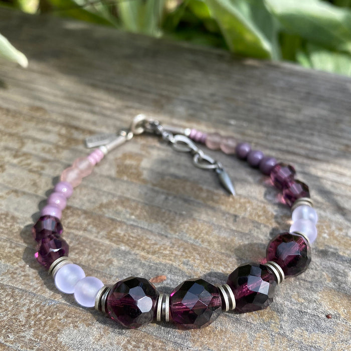 Beaded glass bracelet with amethyst tones from Owen Glass Collection, featuring purple and lavender beads on a stretch cord.