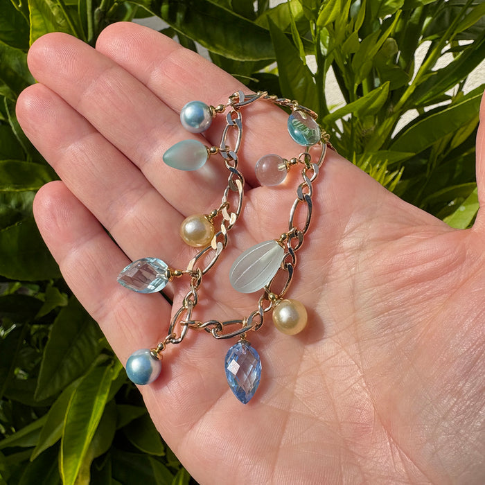 Aqua crystal and gold charm bracelet from Owen Glass Collection with shimmering aqua beads and gold accents.