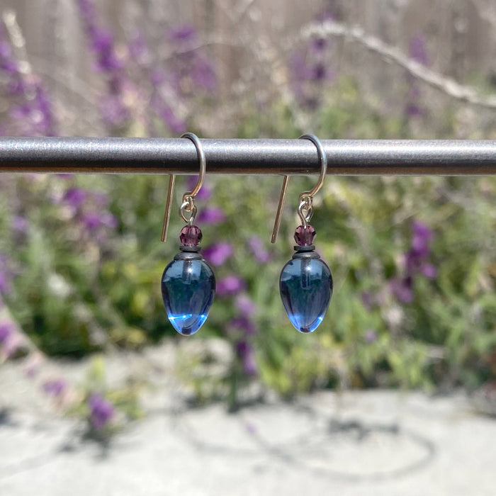 Blue glass and amethyst crystal dangle earrings from Owen Glass Collection with plum-colored accents and silver hooks.