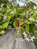 Owen Glass Collection Foxtrot Esprit de Parfum bottle surrounded by citrus and floral flowers, showcasing a vibrant, elegant fragrance.