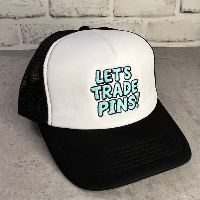 Black and white trucker hat with 'Let's Trade Pins!' text