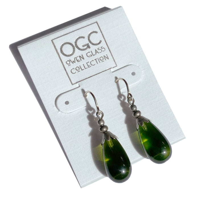 Silver Brights 42-inch green glass and silver earrings from Owen Glass Collection hanging with reflective surfaces.