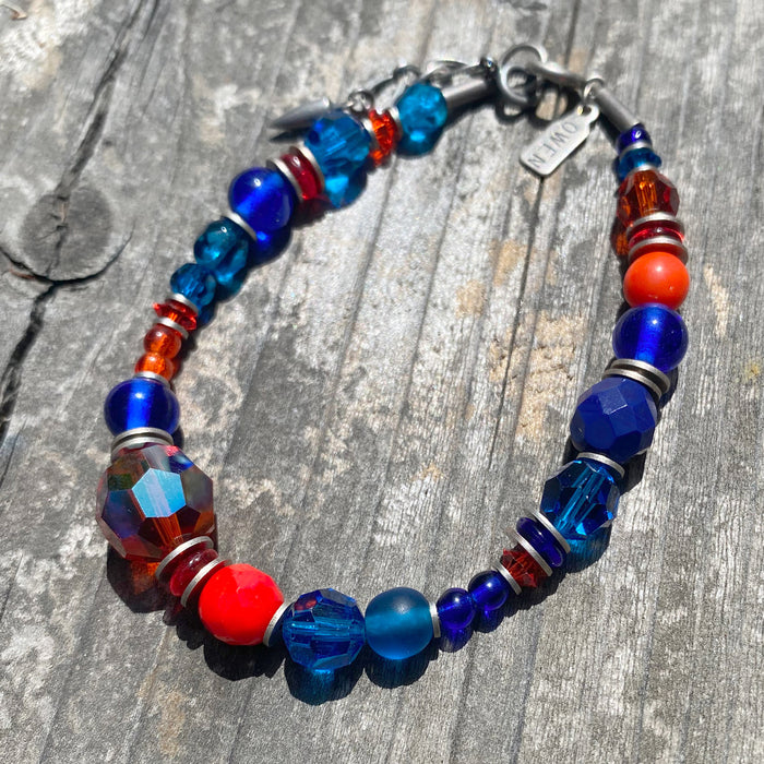 Orange and cobalt glass and crystal beaded bracelet from Owen Glass Collection, featuring colorful, intricate beadwork.