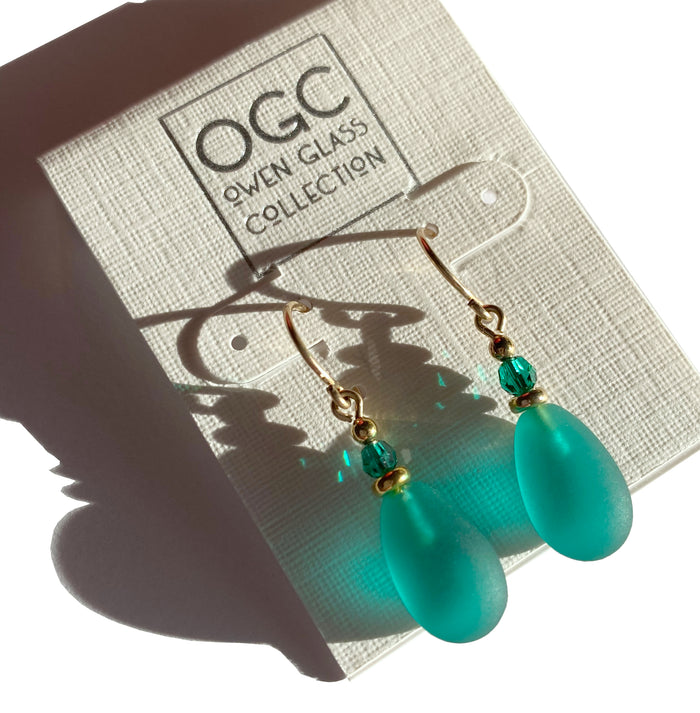 Frosted teal glass and gold earrings featuring raindrop design from Owen Glass Collection, stylish and elegant jewelry accessory.