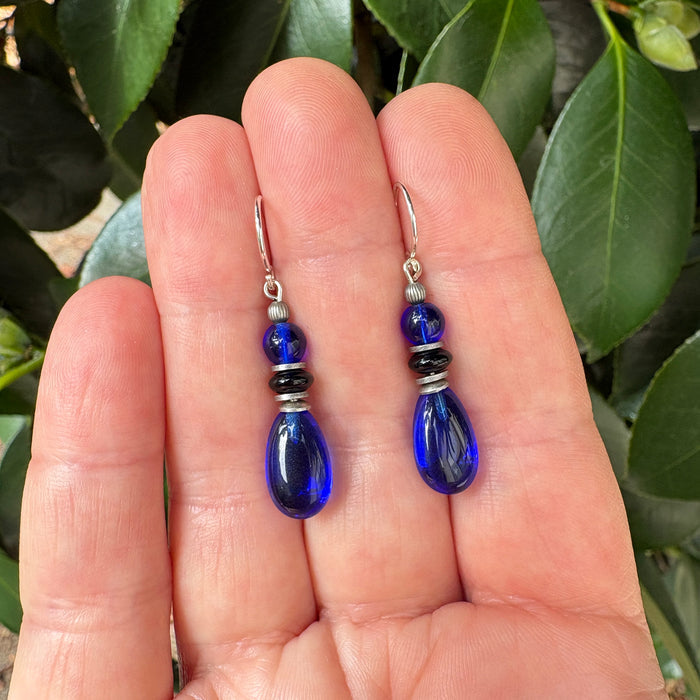Sapphire blue and jet glass drop earrings from Owen Glass Collection featuring elegant, faceted glass beads on silver hooks.
