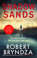 Book cover of 'Shadow Sands' by Robert Bryndza with a silhouette by a lake and red text.