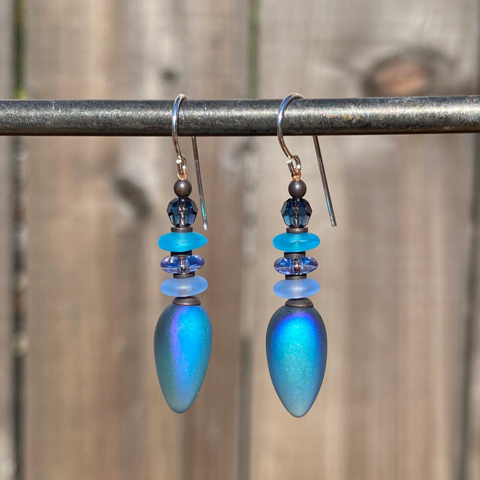 Iridescent blue dangle earrings from Owen Glass Collection, featuring elegant, shimmering glass design with a modern style.